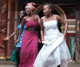 Three actresses dancing on the stage in the production The Merry Wives of Windsor in the language Swahili at Shakespeare's Globe Theatre, London